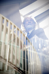 White-haired senior on stairs, low angle view - RMAF000160