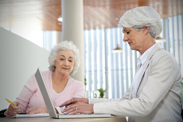 Two senior women working together at laptop - RMAF000174