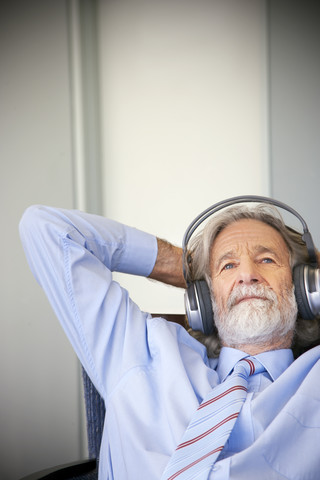 Älterer Mann mit Kopfhörern, der Musik hört, lizenzfreies Stockfoto