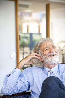 Lachender älterer Mann auf einem Stuhl sitzend, Porträt - RMAF000182