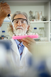 Senior professor filling sample glasses in laboratory - RMAF000184