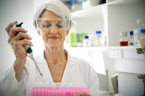 Female professor filling sample glasses in laoratory - RMAF000187