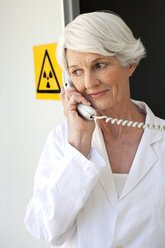 Ältere Frau arbeitet im Labor und telefoniert - RMAF000199