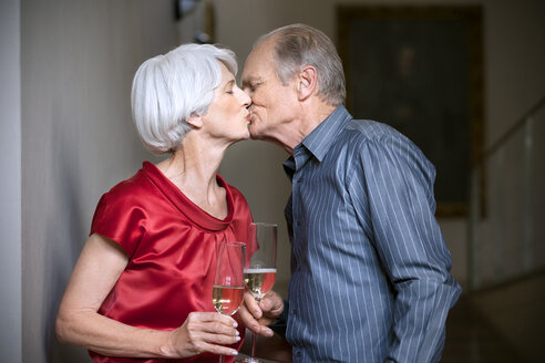 Älteres Paar küsst sich und stößt mit Gläsern an - RMAF000218