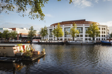 Niederlande, Amsterdam, Hausboot auf der Amstel mit Het Muziektheater im Hintergrund - EVGF002492