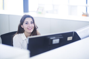 Portrait of smiling young woman at her workplace - SGF001943