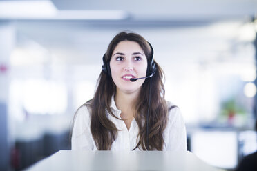 Portrait of young woman with headset in an office - SGF001946