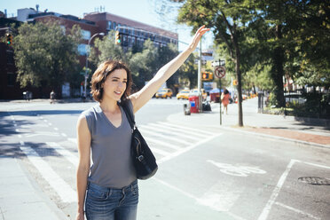 USA, New York City, young woman hailing a taxi - GIOF000421