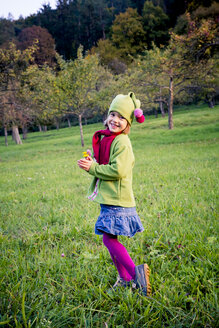 Deutschland, Baden-Württemberg, Lächelndes kleines Mädchen auf einer Wiese im Herbst - LVF004121