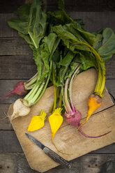 Organic beetroots on chopping board, yellow, white and red - LVF004130