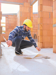 Polier mit Bauplan und Taschenregel auf der Baustelle - LAF001539