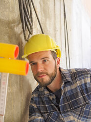 Foreman checking construction work with pocket rule - LAF001549