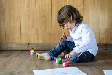 Kleiner Junge sitzt auf Holzboden und benutzt Fingerfarben - KIJF000003