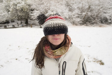 Young woman in winter wearing wooly hat covering her eyes - SKCF000024