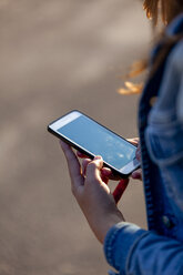 Teenager-Mädchen hält Smartphone in den Händen - HCF000155