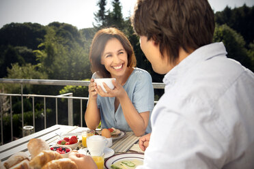 Glückliches Paar beim Frühstück auf dem Balkon - TOYF001416