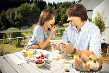 Glückliches Paar beim Frühstück auf dem Balkon - TOYF001417