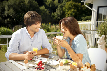 Glückliches Paar beim Frühstück auf dem Balkon - TOYF001418