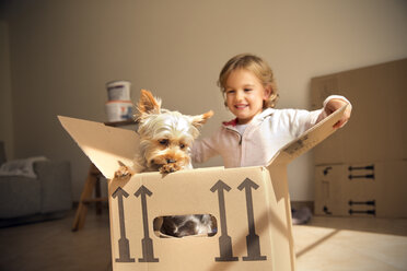 Lächelndes Mädchen mit Hund in einer Pappschachtel - TOYF001419