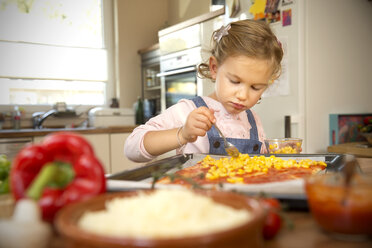 Girl in kitchen preparing pizza - TOYF001430