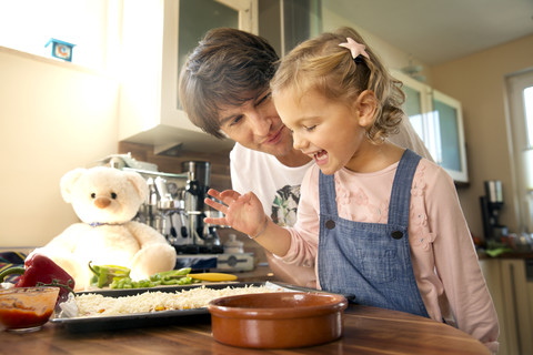 Vater und Tochter in der Küche bei der Zubereitung einer Pizza, lizenzfreies Stockfoto