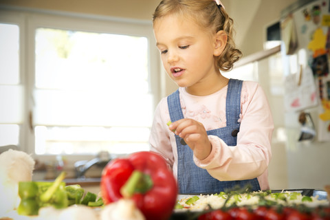 Girl in kitchen preparing pizza stock photo