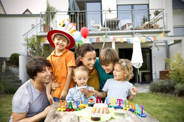 Happy family having a children's birthday party in garden - TOYF001489