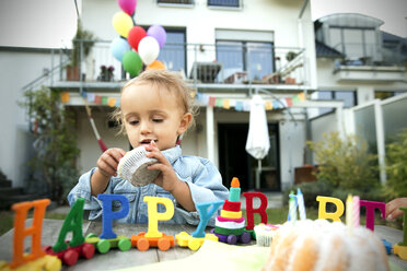 Glückliches Kleinkind, das im Garten Geburtstag feiert - TOYF001491