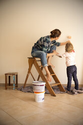 Mutter und Tochter streichen eine Wand - TOYF001495