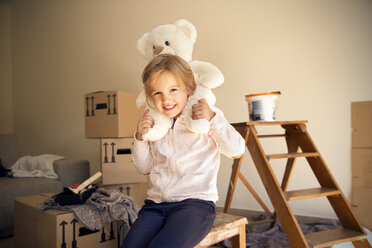 Mädchen mit Teddybär und Pappkartons im Hintergrund - TOYF001510