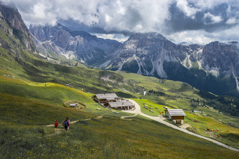 Italien, Dolomiten, Geislergruppe, Wanderer auf dem Weg zu einer Hütte, lizenzfreies Stockfoto