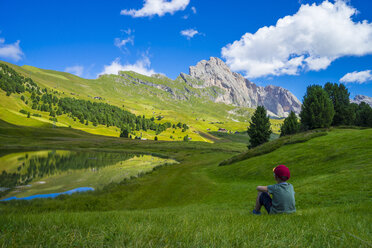 Italy, Dolomites, Odle range, Child resting in front of Seceda and lake Lech Sant - LOMF000090