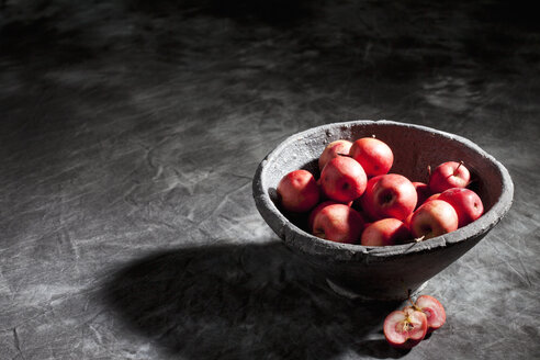 Schale mit roten Bio-Mini-Äpfeln auf grauem Tuch - CSF026687