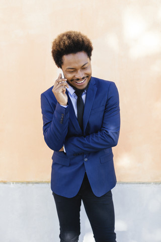Porträt eines lächelnden jungen Geschäftsmannes, der mit einem Smartphone telefoniert, lizenzfreies Stockfoto