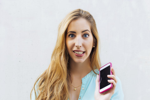 Porträt einer jungen blonden Frau mit Smartphone, lizenzfreies Stockfoto