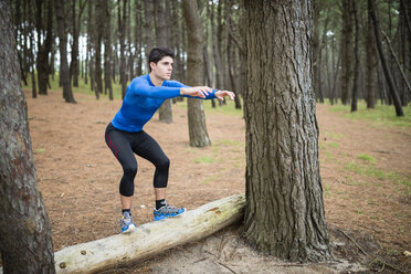 Athlete exercising box jumps in forest - RAEF000627