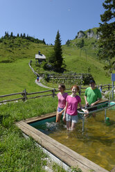 Deutschland, Bayern, Lenggries, Menschen beim Wassertreten auf der Alm am Brauneck - LBF001282