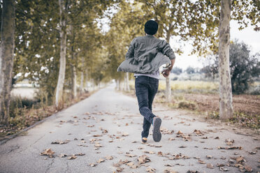 Spanien, Tarragona, Rückenansicht eines jungen Mannes beim Laufen auf einer herbstlichen Landstraße - JRFF000185