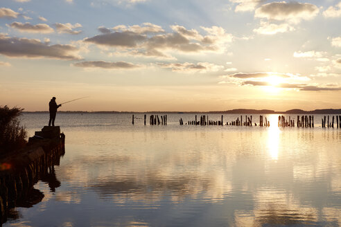 Germany, Mecklenburg-Western Pomerania, Ruegen Island, Glowe, Angler on Spyckerscher See at sunset - SEGF000431