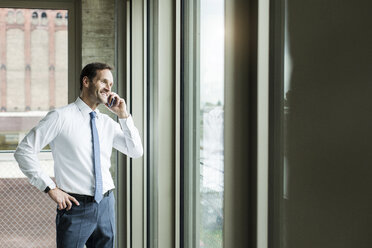 Portrait of businessman telephoning smartphone - UUF005970