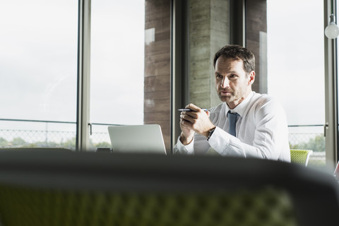 Porträt eines nachdenklichen Geschäftsmannes an seinem Schreibtisch im Büro, lizenzfreies Stockfoto