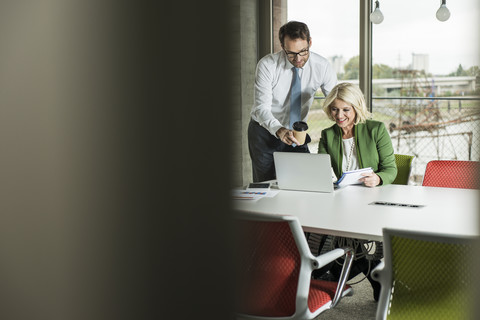 Two business people looking at laptop in an office stock photo