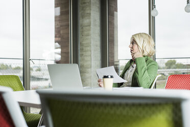 Portrait of pensine businesswoman at her desk in the office - UUF006003