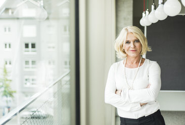 Portrait of smiling blond businesswoman with crossed arms - UUF006009