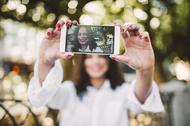 Junge Frau macht ein Selfie mit ihrem Smartphone, Nahaufnahme - RAEF000638