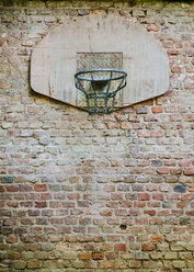 Basketballkorb an einer Backsteinmauer in einem Hinterhof befestigt - DASF000032