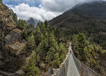 Nepal, Himalaya, Khumbu, Trekker auf Fußgängerbrücke in den Bergen - ALRF000125