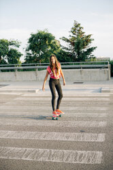 Portrait of smiling skate boarder on zebra crossing - GEMF000471