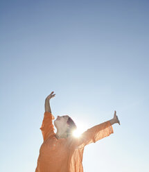 Happy young woman against the sun, blue sky - BFRF001632