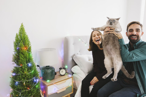 Lachendes Paar mit seiner Katze zu Hause, lizenzfreies Stockfoto